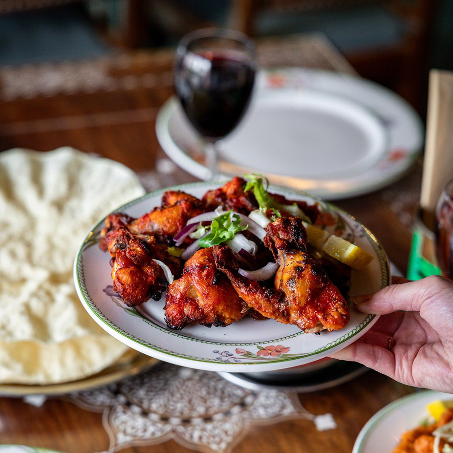 Delhi Darbar Golden-brown chicken pieces are 
beautifully arranged on a plate.